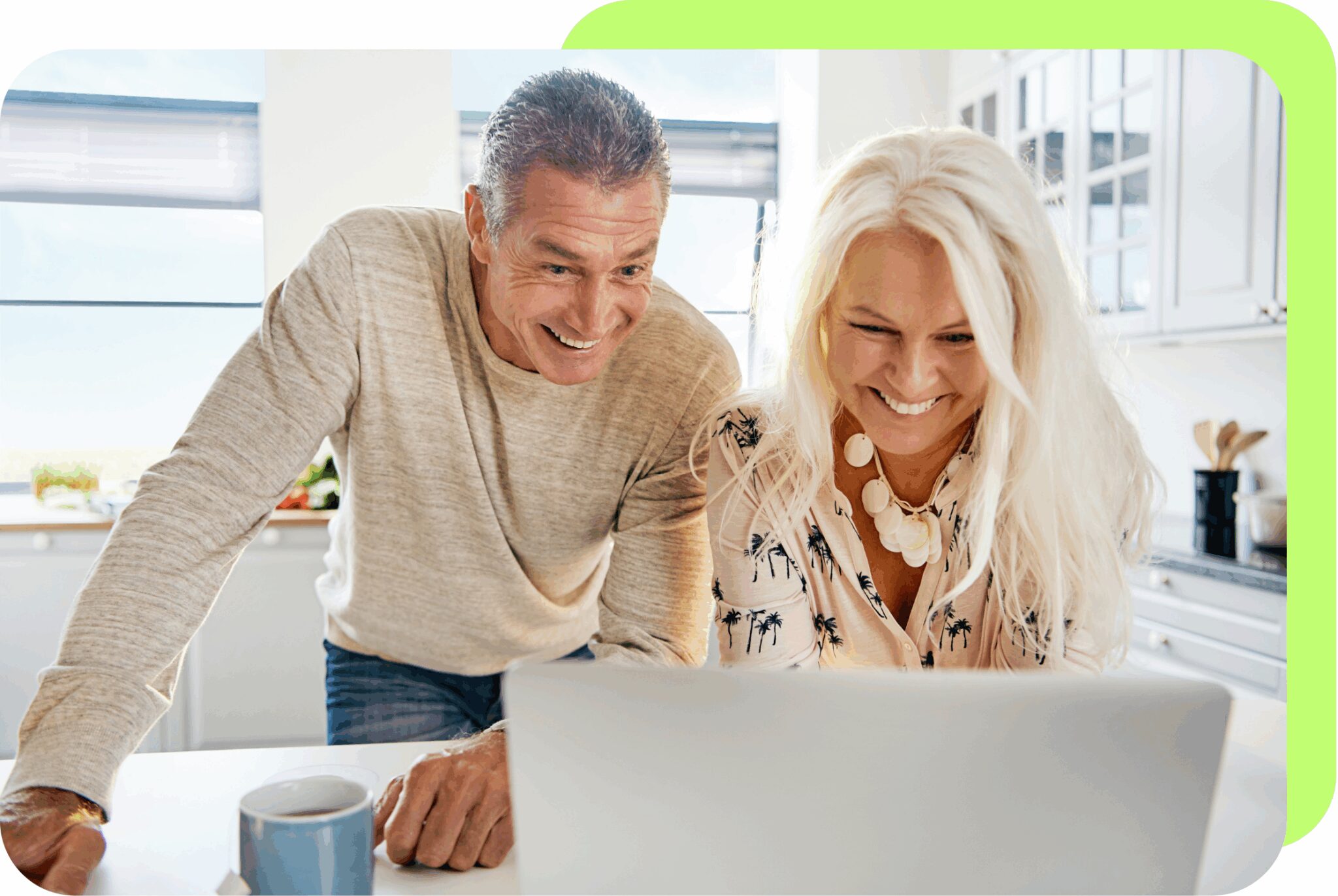 Man and woman looking at a laptop smiling.