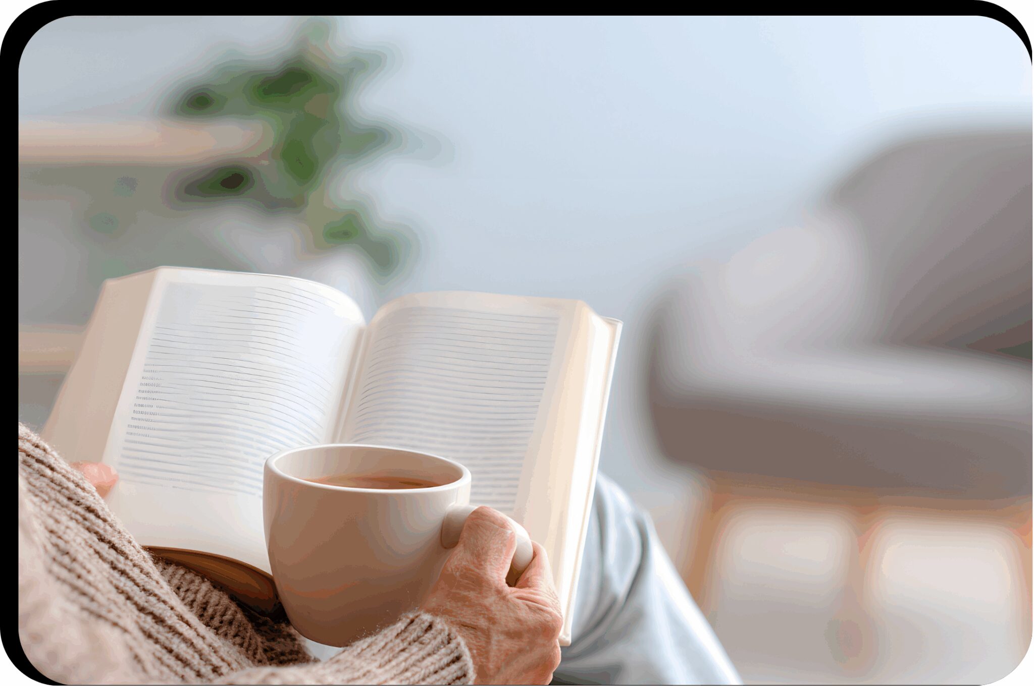 Person reading book with a coffee mug.