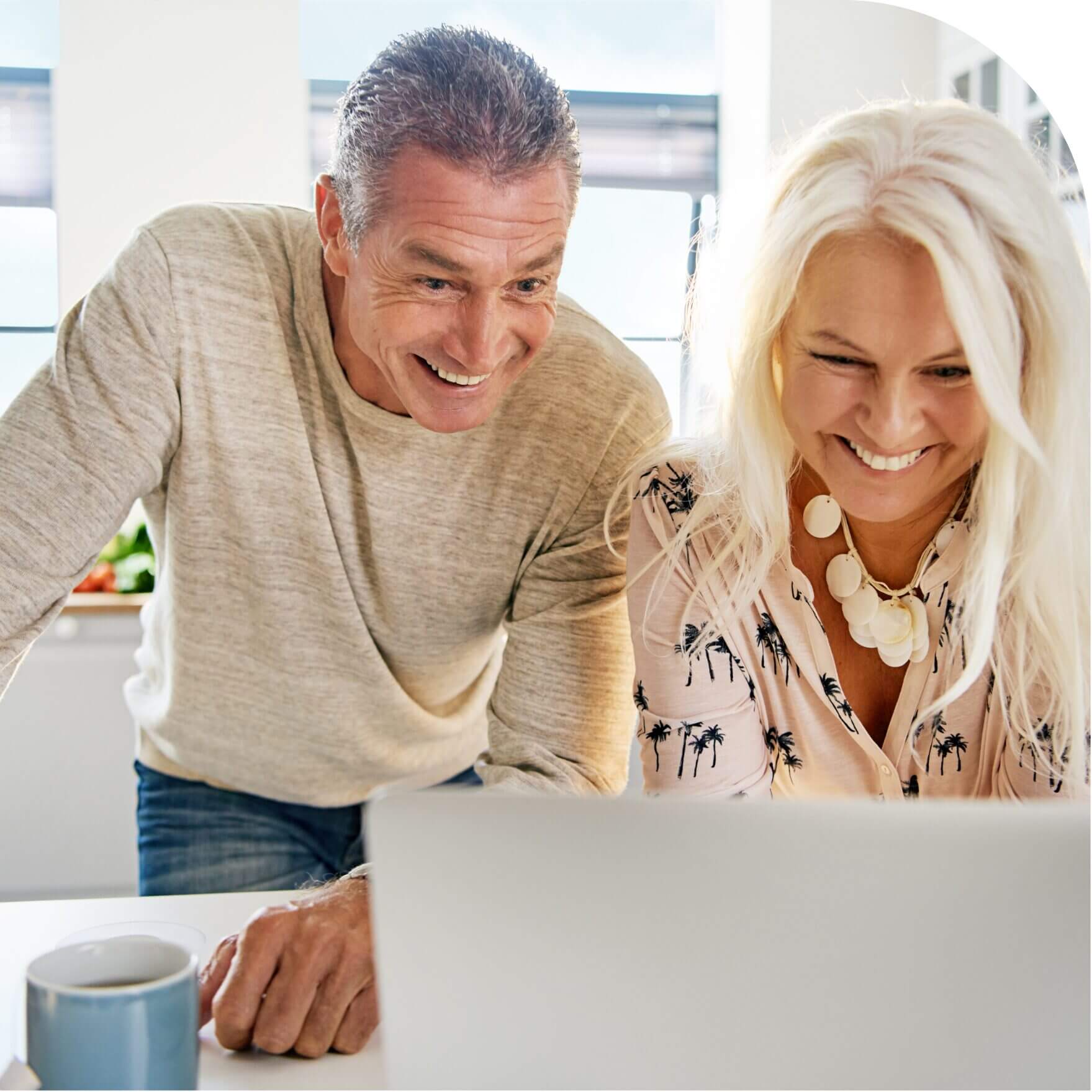Smiling couple looking at a laptop.